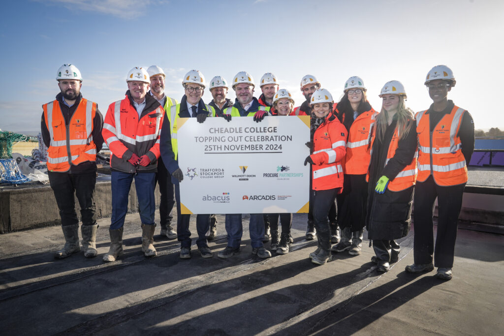 Picture shows: Students and staff from Cheadle College with the Willmott Dixon team celebrating the topping-out milestone at the new campus site.