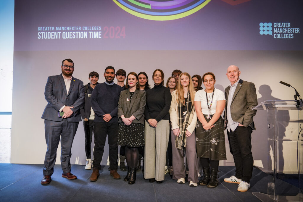 Students stook in front of the Student Question Time presentation screen