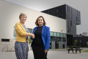 two women shaking hands and smiling